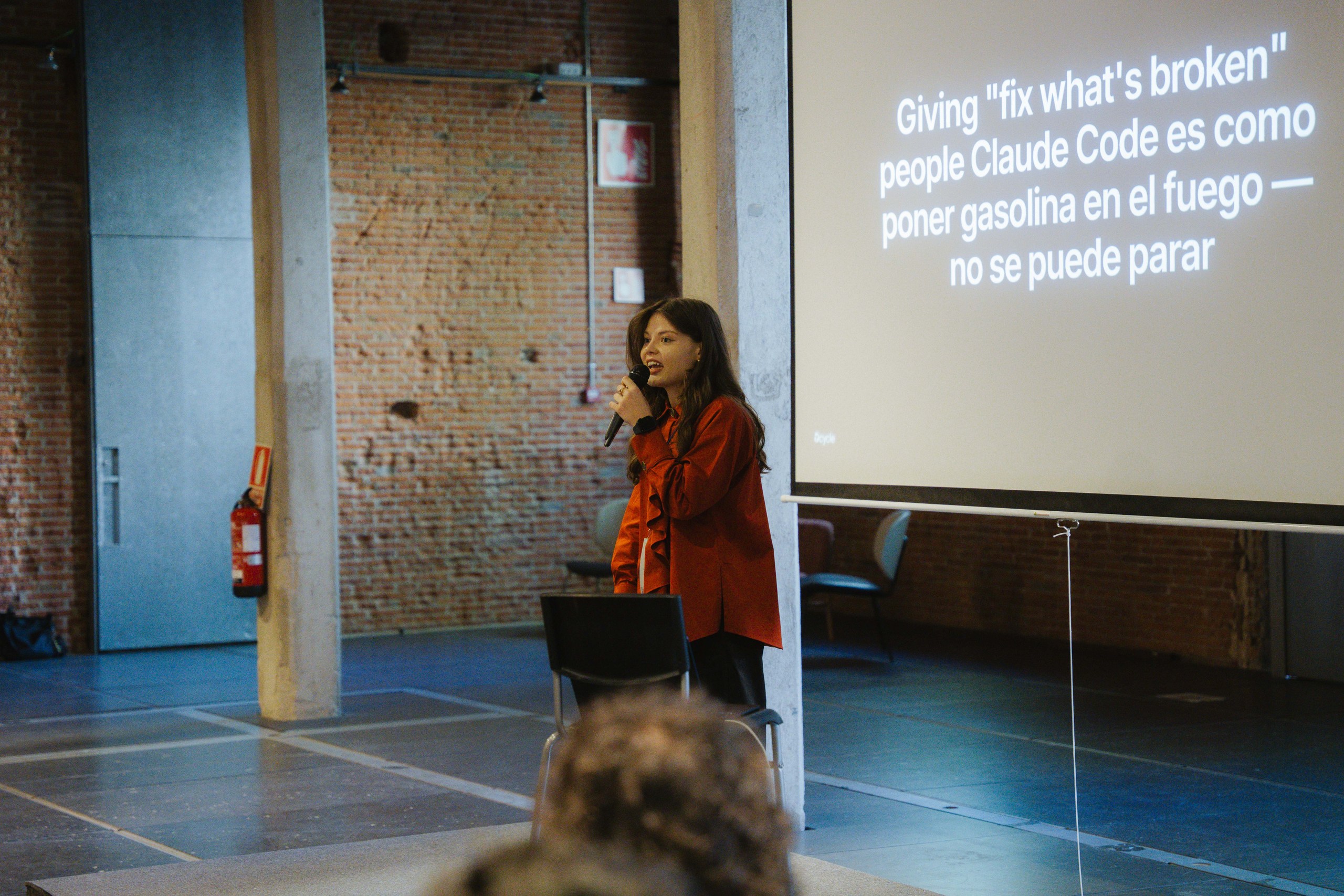 Speaker showing slide about Claude Code adoption in customer-facing teams at Ahead Madrid