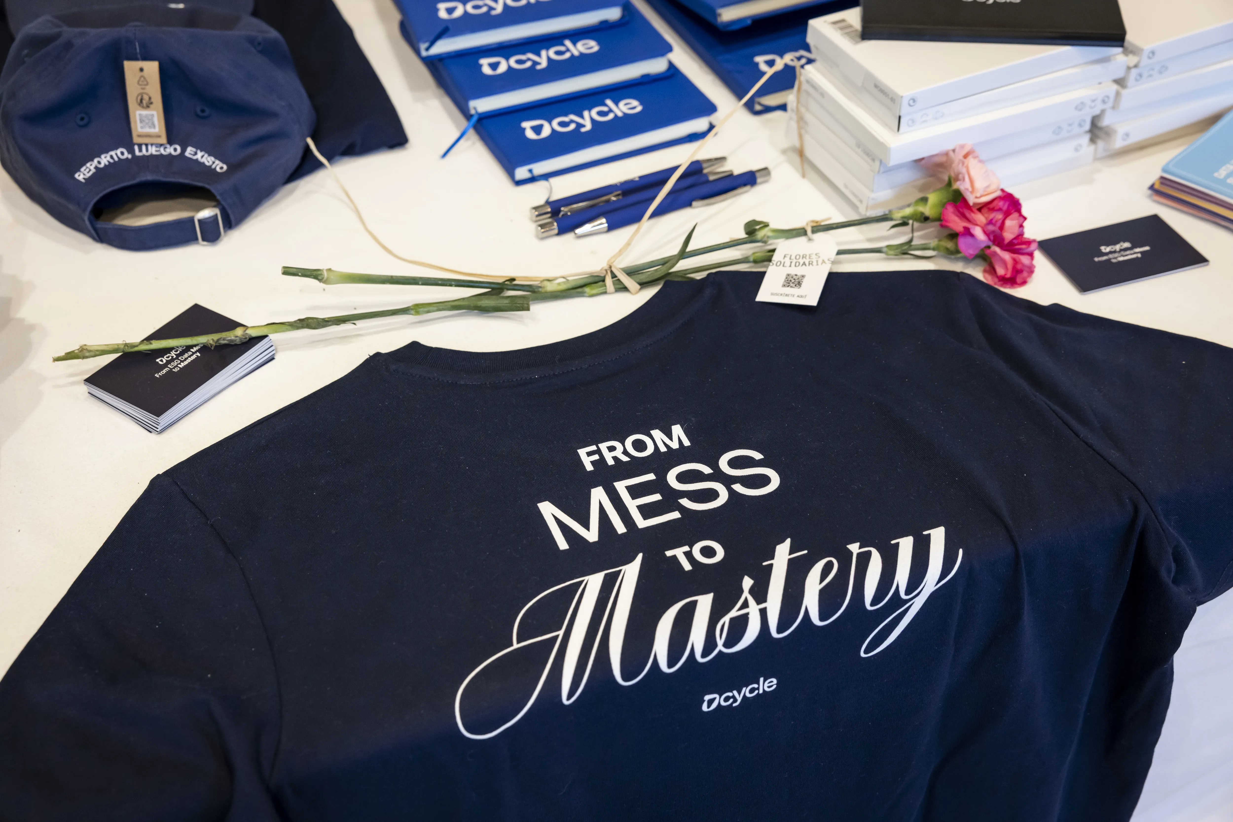 Dcycle Merchandise-Tisch mit From Mess to Mastery T-Shirts, Caps und Notizbloecken